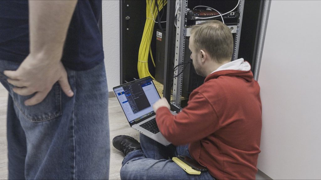 Techniker richten im Serverraum der Zahnarztpraxis die Technik für den Softwarewechsel ein